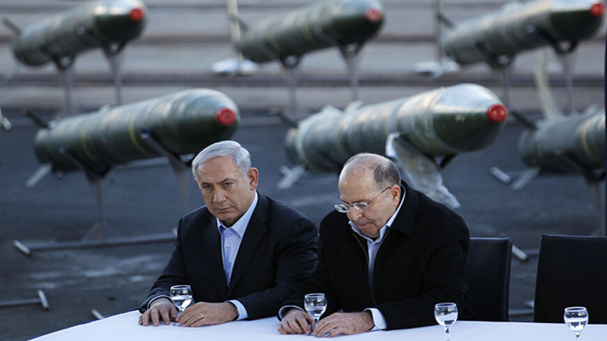Israel's Prime Minister Benjamin Netanyahu (L) and Defense Minister Moshe Yaalon sit in front of a display of M302 rockets, found aboard the Klos C ship, at a navy base in the Red Sea resort city of Eilat March 10, 2014. Netanyahu, displaying on Monday what Israel said were seized Iranian-supplied missiles bound for militants in Gaza, called on the West not to be fooled by Tehran's diplomatic outreach over its nuclear programme. REUTERS/Amir Cohen (ISRAEL - Tags: POLITICS MILITARY CIVIL UNREST) - RTR3GGUG