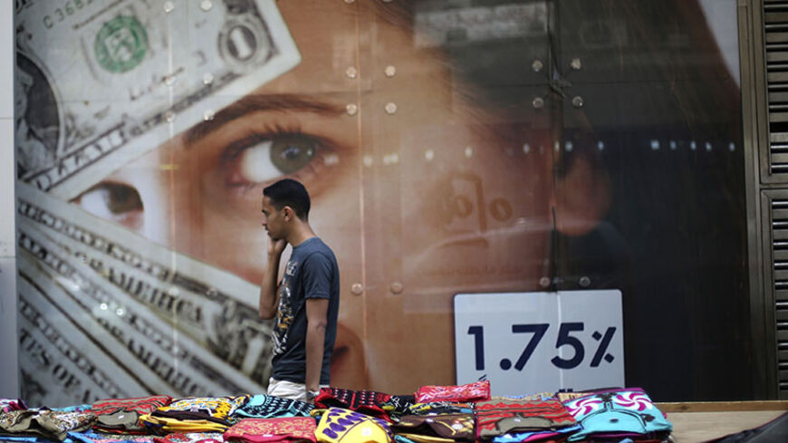 A pedestrian walks past a currency exchange shop and street stalls after Abdel Fattah al-Sisi took more than 90 percent of the vote in a presidential election, according to provisional results,  in Cairo, May 29, 2014. The stock market, which fell 2.3 percent on Wednesday as some players said the turnout was a disappointment, was down two percent by midday on Thursday. On the black market, the Egyptian pound weakened slightly.REUTERS/Amr Abdallah Dalsh (EGYPT - Tags: POLITICS ELECTIONS CIVIL UNREST BUSINESS