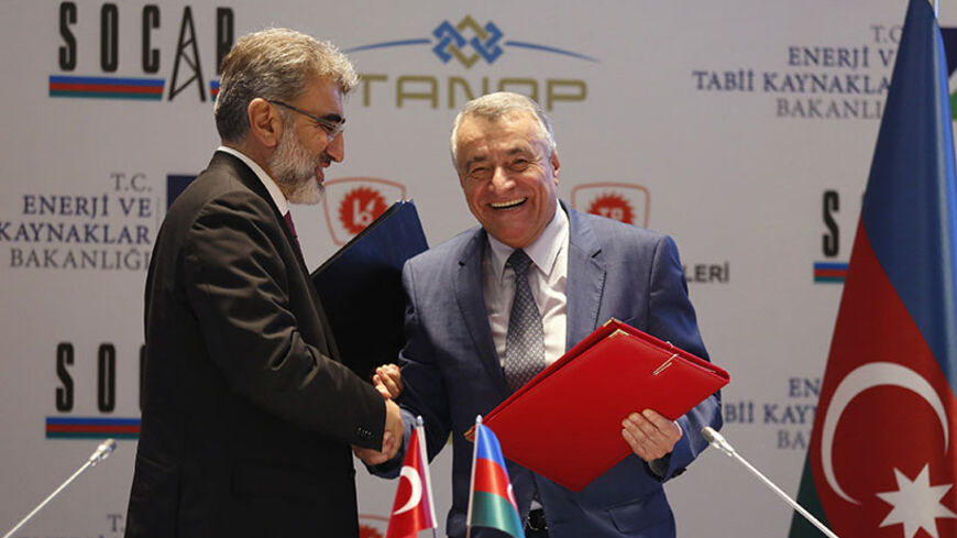Turkey's Energy Minister Taner Yildiz (L) shakes hands with his Azeri counterpart Natik Aliyev during a signing ceremony in Istanbul May 30, 2014. Turkey's state oil company TPAO signed a deal on Friday to acquire French energy company Total's 10 percent stake in Azerbaijan's Shah Deniz gas project, at a signing ceremony in Istanbul. The agreement increases TPAO's stake in the project to 19 percent from a previous 9 percent, while Total exits the project. Financial details of the agreement were not disclose