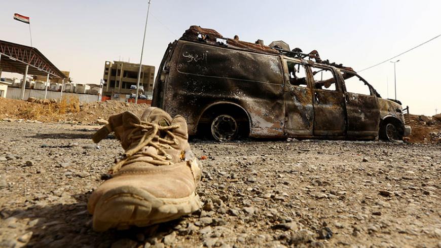 A burnt vehicle belonging to Iraqi security forces is pictured at a checkpoint in east Mosul, one day after radical Sunni Muslim insurgents seized control of the city, June 11, 2014. Sunni insurgents from an al Qaeda splinter group extended their control from the northern city of Mosul on Wednesday to an area further south that includes Iraq's biggest oil refinery in a devastating show of strength against the Shi'ite-led government. REUTERS/Stringer (IRAQ - Tags: CIVIL UNREST POLITICS TPX IMAGES OF THE DAY 