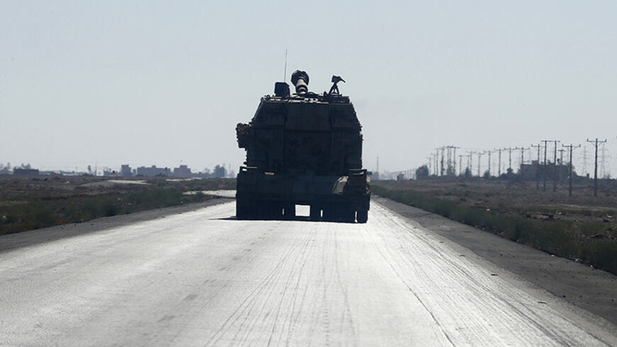 A Jordanian trailer carrying a military tank drives along a road in Ruweished, near Jordan's eastern border with Iraq, east of Amman June 23, 2014. Sunni tribesmen took control of a border crossing between Iraq and Jordan after Iraq's army pulled out of the area following clashes with rebels, Iraqi and Jordanian intelligence sources said on Monday. It was not immediately clear if the tribesmen's seizure of the Turaibil crossing, the only legal crossing point between Iraq and Jordan, late on Sunday was part 