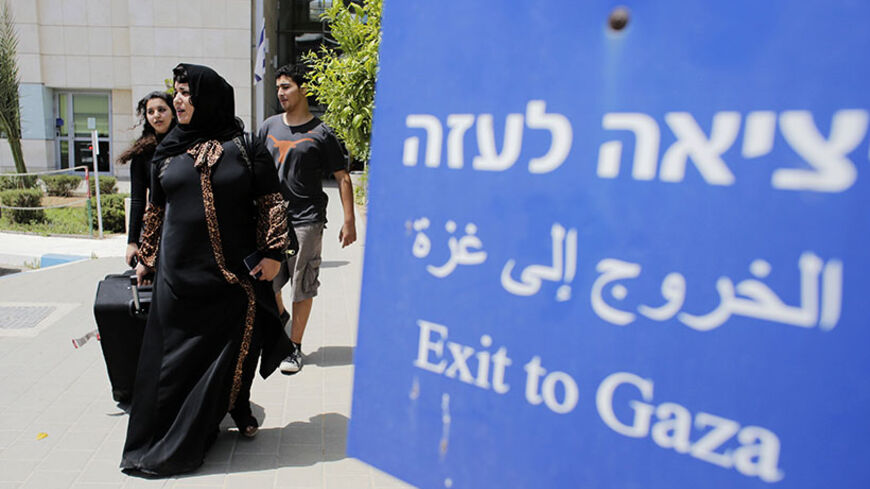 Palestinians walk out of Israel's Erez Crossing after leaving Gaza July 13, 2014. According to a spokesperson for Israel's Coordination of Government Activities in the Territories (COGAT), about 850 Palestinians with dual citizenship left Gaza on Sunday at the request of their foreign embassies. Israeli naval commandos clashed with Hamas militants in a raid on the coast of the Gaza Strip on Sunday, in what appeared to be the first ground assault of a six-day Israeli offensive on the territory aimed at stopp