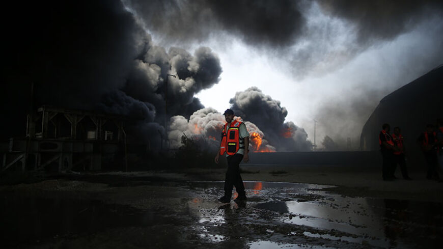 A Palestinian firefighter participates in efforts to put out a fire at Gaza's main power plant, which witnesses said was hit in Israeli shelling, in the central Gaza Strip July 29, 2014.  Israeli tank fire hit the fuel depot of the Gaza Strip's only power plant on Tuesday, witnesses said, cutting electricity to Gaza City and many other parts of the Palestinian enclave of 1.8 million people.An Israeli military spokeswoman had no immediate comment and said she was checking the report. Israel launched its Gaza