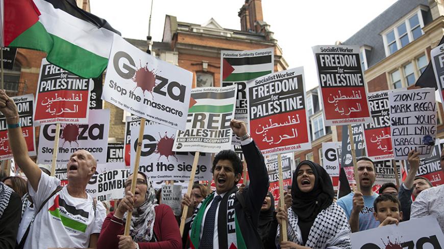 Protesters chant during a pro-Gaza demonstration outside the Israeli embassy in London August 1, 2014. Israel launched its Gaza offensive on July 8 in response to a surge of rocket attacks by Gaza's dominant Hamas Islamists. Hamas said that Palestinians would continue confronting Israel until its blockade on Gaza was lifted. REUTERS/Neil Hall (BRITAIN - Tags: POLITICS CIVIL UNREST CONFLICT) - RTR40YDH