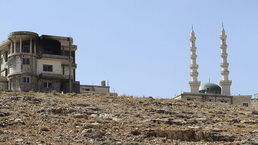 Damage is seen on a building and a mosque from the fighting between Lebanese army soldiers and Islamist militants, in the Sunni Muslim border town of Arsal, in eastern Bekaa Valley August 7, 2014. Militant Islamists have mostly withdrawn from the Lebanese border town of Arsal, which they seized at the weekend, taking with them captive Lebanese soldiers, militant and security sources said on Thursday, as a truce to end the deadly battle appeared to hold. REUTERS/Ahmad Shalha (LEBANON - Tags: POLITICS CIVIL U