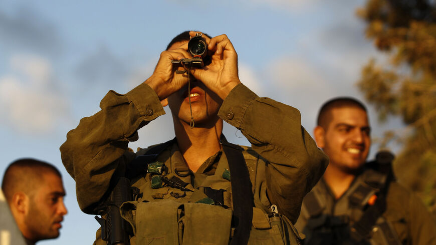 An Israeli soldier looks at the Gaza Strip through a monocular on the Israeli border August 9, 2014. Israel launched more than 30 air attacks in Gaza on Saturday, killing five Palestinians, and militants fired rockets at Israel as the conflict entered a second month, defying international efforts to revive a ceasefire. REUTERS/Amir Cohen (ISRAEL - Tags: POLITICS CONFLICT MILITARY TPX IMAGES OF THE DAY) - RTR41TE3