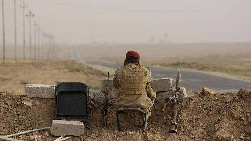 A Kurdish fighter keeps guard while overlooking positions of Islamic State militants near Mosul in northern Iraq August 19, 2014. Sunni Muslim fighters led by the Islamic State swept through much of northern and western Iraq in June, capturing the Sunni cities of Tikrit and Mosul as well as the Mosul dam, which controls water and power supplies to millions of people down the Tigris river valley.                REUTERS/Youssef Boudlal (IRAQ - Tags: CIVIL UNREST POLITICS MILITARY TPX IMAGES OF THE DAY) - RTR4