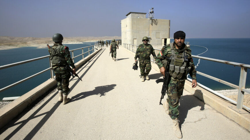 Peshmerga fighters walk at Mosul Dam in northern Iraq August 21, 2014. Iraqi and Kurdish forces recaptured Iraq's biggest dam from Islamist militants with the help of U.S. air strikes to secure a vital strategic objective in fighting that threatens to break up the country, Kurdish and U.S. officials said on Monday.  REUTERS/Youssef Boudlal (IRAQ - Tags: CIVIL UNREST POLITICS MILITARY) - RTR438UJ