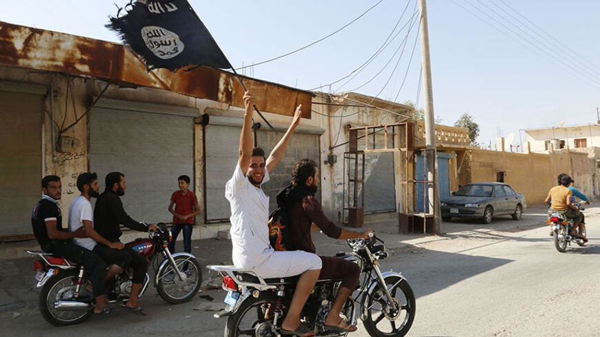 A resident of Tabqa city touring the streets on a motorcycle waves an Islamist flag in celebration after Islamic State militants took over Tabqa air base, in nearby Raqqa city August 24, 2014. Islamic State militants stormed the air base in northeast Syria on Sunday, capturing most of it from government forces after days of fighting over the strategic location, a witness and a monitoring group said. Fighting raged inside the walls of the Tabqa air base, the Syrian army's last foothold in an area otherwise c