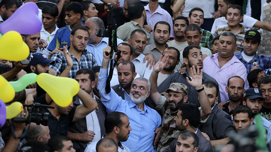 Hamas Gaza leader Ismail Haniyeh holds a gun as he appears for the first time since the start of a seven-week conflict during a rally by Palestinians celebrating what they said was a victory over Israel, in Gaza City August 27, 2014. An open-ended ceasefire in the Gaza war held on Wednesday as Prime Minister Benjamin Netanyahu faced strong criticism in Israel over a costly conflict with Palestinian militants in which no clear victor emerged. REUTERS/Suhaib Salem (GAZA - Tags: POLITICS CIVIL UNREST CONFLICT 
