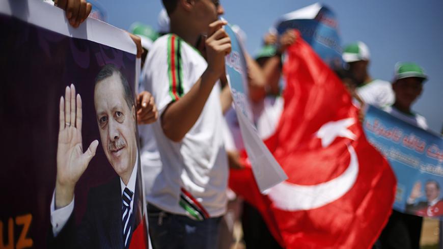 Palestinian youths take part during a rally in support of Turkish Prime Minister Recep Tayyip Erdogan (seen on banner), at the Seaport of Gaza City June 18, 2013. REUTERS/Suhaib Salem (GAZA - Tags: POLITICS CIVIL UNREST) - RTX10RQC