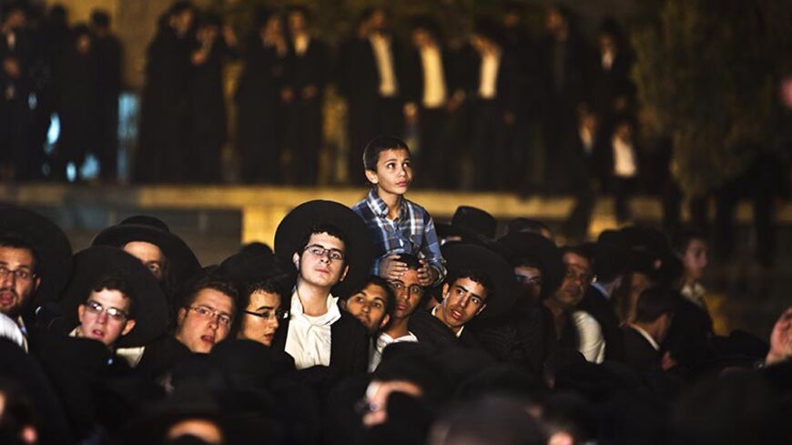 Ultra-Orthodox Jewish men lift a boy during the funeral of Rabbi Ovadia Yosef, the spiritual leader of the ultra-religious Shas political party, in Jerusalem October 7, 2013. More than half a million mourners turned out on Monday for the funeral of Yosef, an Iraqi-born sage who transformed an Israeli underclass of Sephardic Jews of Middle East heritage into a powerful political force. REUTERS/ Nir Elias (JERUSALEM - Tags: POLITICS RELIGION) - RTX1436M