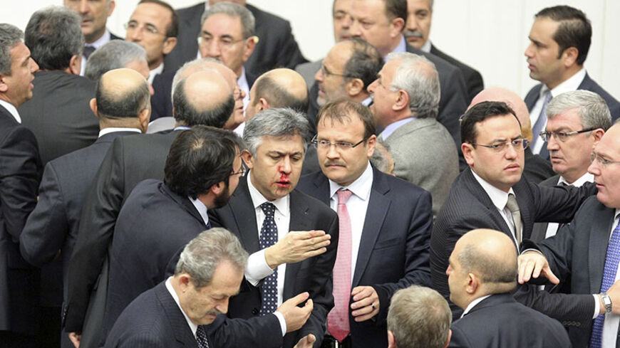 Member of parliament (MP) from the main opposition Republican People's Party (CHP) Ali Ihsan Kokturk's nose bleeds as MPs from the ruling AK Party (AKP) and CHP scuffle during a debate on a draft law which will give the government tighter control over the appointment of judges and prosecutors, at a parliamentary session in Ankara early February 15, 2014. REUTERS/Stringer (TURKEY - Tags: POLITICS CIVIL UNREST TPX IMAGES OF THE DAY) - RTX18UO8