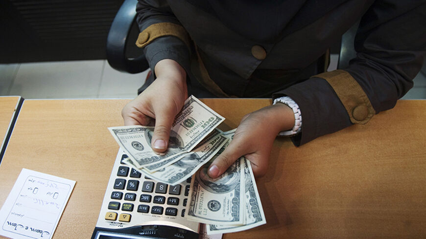 EDITORS' NOTE: Reuters and other foreign media are subject to Iranian restrictions on their ability to report, film or take pictures in Tehran.

A currency exchange dealer counts U.S. dollar banknotes for a client at a shop in northern Tehran October 3, 2010. Iran's currency, the rial, defied central bank attempts to revive its value on Sunday, remaining weak after falling 13 percent against the dollar last week. Morteza Nikoubazl (IRAN - Tags: BUSINESS POLITICS) - RTXSZ96