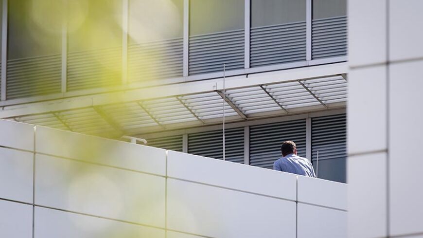 An employee of the International Criminal Court (ICC) building in The Hague, The Netherlands, stands on its roof being before evacuated by police, on August 3, 2013. The man had been standing on the roof of the tribunal for sixteen hours before the police arrested him. According to first reports the man wanted to commit suicide.  AFP PHOTO / ANP - EVERT JAN DANIELS = netherlands out        (Photo credit should read Evert-Jan Daniels/AFP/Getty Images)