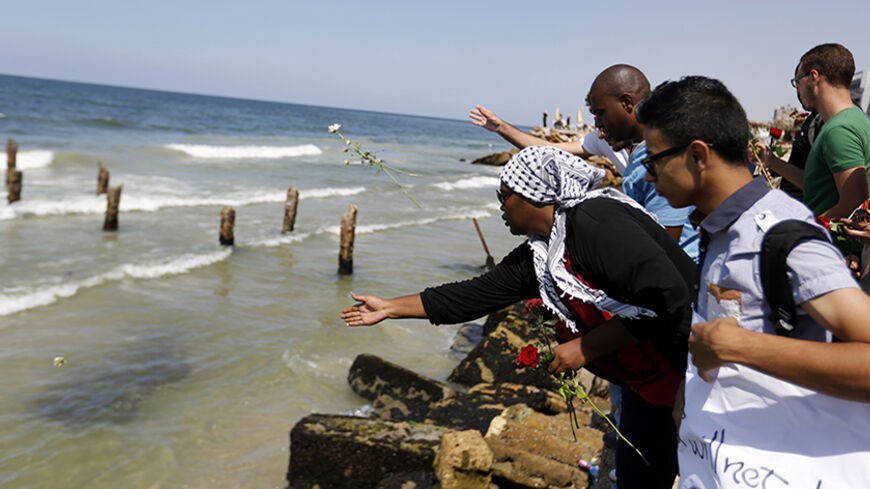 Palestinians throw roses in the Mediterranean sea off the coast of Gaza City on September 18, 2014 in mourning over the loss of fellow Palestinians who had boarded a boat to Europe that sank off Malta last week. In one of the deadliest migrant shipwrecks on record, the boat, with 500 people on board, was intentionally capsized by traffickers as it made its way from Egypt to Italy. Only 10 people are known to have survived, among them four Palestinians from the 100 Gazans believed to have been on board.  AFP