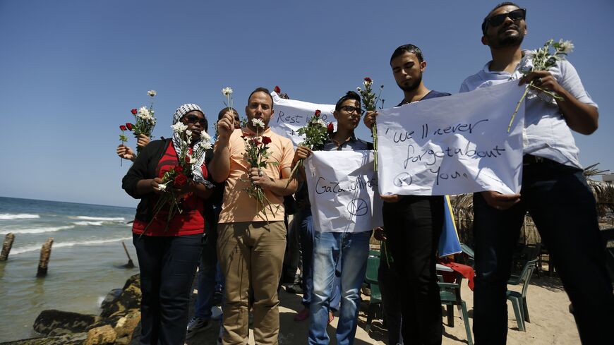 A group of Palestinians prepare to throw roses in the Mediterranean sea off the coast of Gaza City on September 18, 2014 in mourning over the loss of fellow Palestinians who had boarded a boat to Europe that sank off Malta last week. In one of the deadliest migrant shipwrecks on record, the boat, with 500 people on board, was intentionally capsized by traffickers as it made its way from Egypt to Italy. Only 10 people are known to have survived, among them four Palestinians from the 100 Gazans believed to ha
