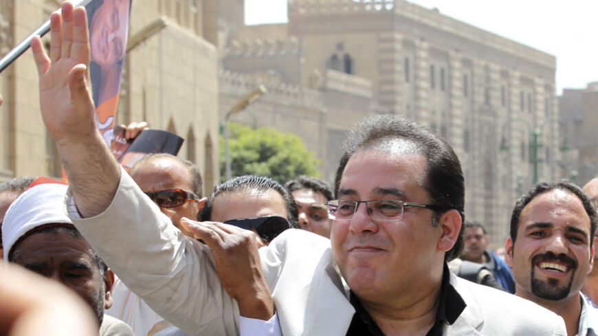 Egyptian presidential candidate Ayman Nour, surrounded by his supporters, waves as he makes his way to Andalus Palace, where candidates submit candidacy papers, in Cairo April 6, 2012, days before the door for nominations is set to close.   REUTERS/Mohamed Abd El Ghany (EGYPT - Tags: POLITICS ELECTIONS) - RTR30FAQ