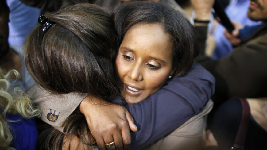 A supporter of Yair Lapid's Yesh Atid (There's a Future) party hugs Ethiopian immigrant and party candidate Penina Tamnu-Shata (facing camera) as they celebrate exit poll results at the party's headquarters in Tel Aviv January 22, 2013. Israel's parliament, long heavy with retired generals, is getting a new look, with a freshman class that includes two youth protest leaders, an Ethiopian immigrant, a high tech millionaire and more women than ever. Picture taken January 22, 2013. REUTERS/Ammar Awad (ISRAEL -