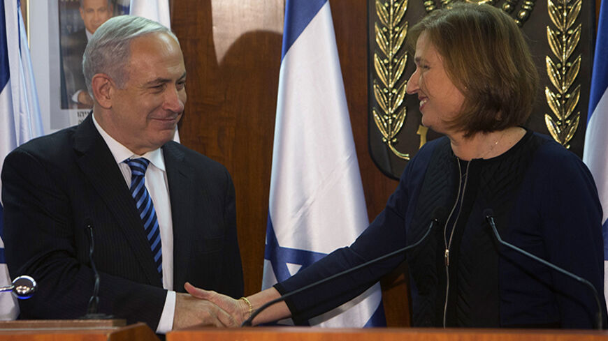 Israel's Prime Minister Benjamin Netanyahu (L) shakes hands with former Foreign Minister Tzipi Livni, head of the centrist Hatenuah party, during their joint statement at the Knesset, the Israeli parliament, in Jerusalem February 19, 2013. Netanyahu took his first step in forming a new government on Tuesday saying he had signed a coalition deal with Livni, who will handle efforts to renew stalled Middle East diplomacy. REUTERS/Ronen Zvulun (JERUSALEM - Tags: POLITICS) - RTR3DZYL