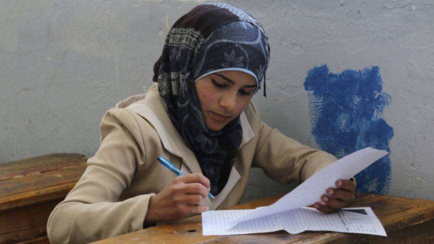 A student sits for her exam in what activists say is the only school in Hama not controlled by the Syrian regime, located in an area controlled by the Free Syrian Army, in Hama countryside May 10, 2014. Picture taken May 10, 2014. REUTERS/Ahmad Rif (SYRIA - Tags: POLITICS CIVIL UNREST CONFLICT EDUCATION) - RTR3OPCU