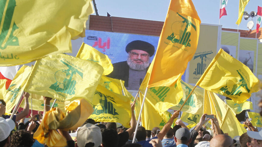 Residents watch Hezbollah leader Sayyed Hassan Nasrallah on a screen during his televised speech at a festival celebrating Resistance and Liberation Day, in Bint Jbeil May 25, 2014. The event commemorates the 14th anniversary of Israel's withdrawal from southern Lebanon.   REUTERS/Sharif Karim (LEBANON - Tags: POLITICS ANNIVERSARY) - RTR3QT8E