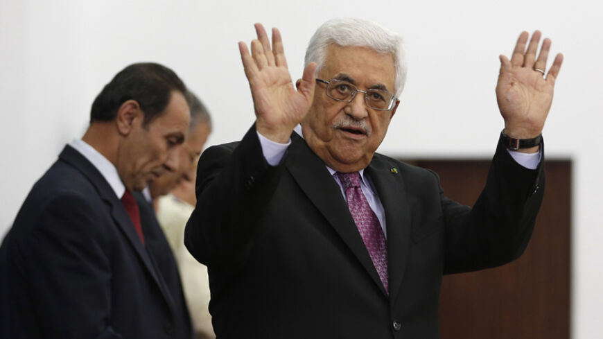 Palestinian President Mahmoud Abbas waves during a swearing-in ceremony of the unity government, in the West Bank city of Ramallah June 2, 2014. Abbas swore in a unity government on Monday after overcoming a last-minute dispute with the Hamas Islamist group.
 REUTERS/Mohamad Torokman (WEST BANK - Tags: POLITICS) - RTR3RT40