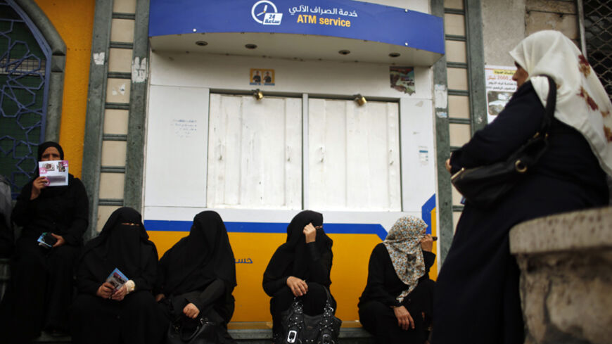 Palestinian employees paid by the Palestinian Authority wait to receive their salaries outside a closed bank after a scuffle with employees appointed by Hamas since 2007, in Gaza City June 5, 2014. A Palestinian unity government formed by President Mahmoud Abbas and the Islamist Hamas group faced its first and serious challenge on Thursday when civil servants of Hamas, who were not on a payment list, scuffled with those cashing their salaries. Civil servants employed by Hamas since 2007 arrived and prevente