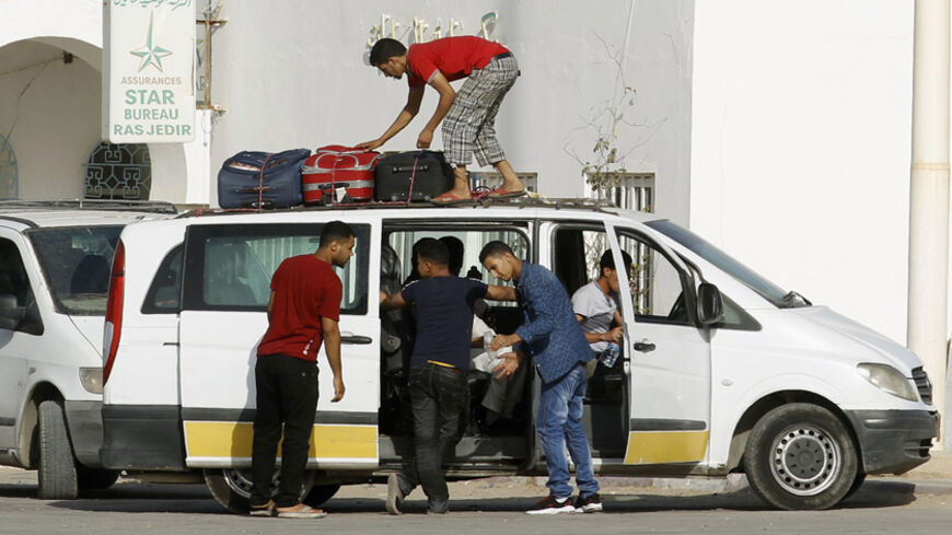 Libyan men load their belongings onto a vehicle at the border crossing at Ras el-Jedir Ben Guerdane, southeast of Tunis August 2, 2014. Western governments, who have mostly evacuated their diplomats from Libya after two weeks of fighting, hope the new parliament can create space for negotiations after the worst clashes since the 2011 war that ousted Muammar Gaddafi. REUTERS/Zoubeir Souissi (TUNISIA - Tags: SOCIETY IMMIGRATION POLITICS CIVIL UNREST CONFLICT) - RTR4112I
