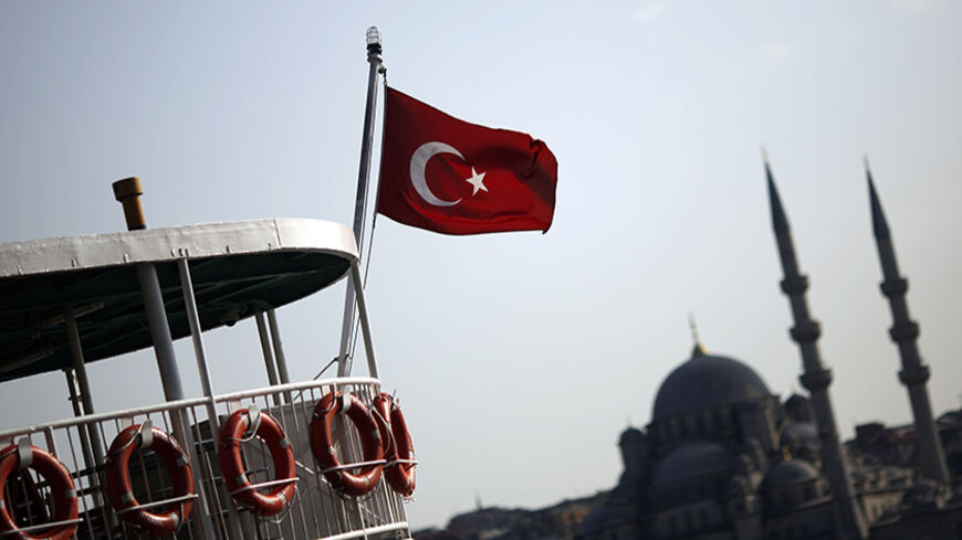 A Turkish flag, with the Ottoman-era New mosque in the background, flies over a passenger ferry in Istanbul August 20, 2014. REUTERS/Murad Sezer (TURKEY - Tags: RELIGION TRAVEL) - RTR434PO