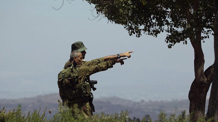 Israeli soldiers observe the Syrian side of the Quneitra border crossing between the Israeli-controlled Golan Heights and Syria, August 29, 2014. U.N. officials shuttled along the rocky frontier between Syria and the Israeli-occupied Golan Heights on Friday, trying to establish the whereabouts of 44 United Nations peacekeepers seized by al-Qaeda-linked militants inside Syria. Israeli forces took up positions at Quneitra, a fortified crossing between Syria and the Golan, barely 400 meters (437 yards) from Nu