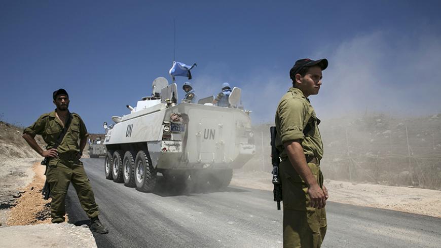 Members of the United Nations Disengagement Observer Force (UNDOF) ride armoured personnel carriers (APCs) past Israel soldiers in the Israeli-occupied Golan Heights, before crossing into Syria August 31, 2014. The head of the Fijian army said on Sunday negotiations for the release of 44 soldiers seized by an al Qaeda-linked group on the Syrian side of the Golan Heights were being pursued but he worried there had been no word on where his men are being held. REUTERS/Baz Ratner (CIVIL UNREST POLITICS CONFLIC