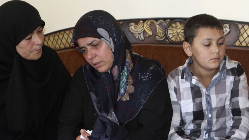 The mother (C) of Lebanese soldier Abbas Medlej, who was beheaded by Islamic State militants in Arsal, mourns during his funeral in his hometown in Ansar, south Baalbak September 7, 2014. Islamic State militants have beheaded the captive Lebanese soldier, images published on social media showed on Saturday, the second Lebanese soldier to be killed in captivity by the group since it raided a Lebanese border town last month. REUTERS/Ahmad Shalha (LEBANON - Tags: POLITICS CIVIL UNREST OBITUARY) - RTR458II