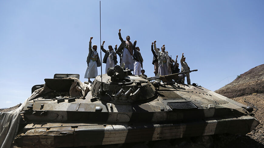 Shi'ite Houthi rebels gesture as they stand atop an army vehicle they took from the compound of the army's First Armoured Division in Sanaa September 22, 2014. Yemen's Shi'ite Muslim rebels signed an agreement with other political parties on Sunday to form a more inclusive government after rebels advanced on major state institutions in the capital Sanaa, largely unopposed by troops and security forces. REUTERS/Khaled Abdullah (YEMEN - Tags: POLITICS CIVIL UNREST MILITARY) - RTR477XJ