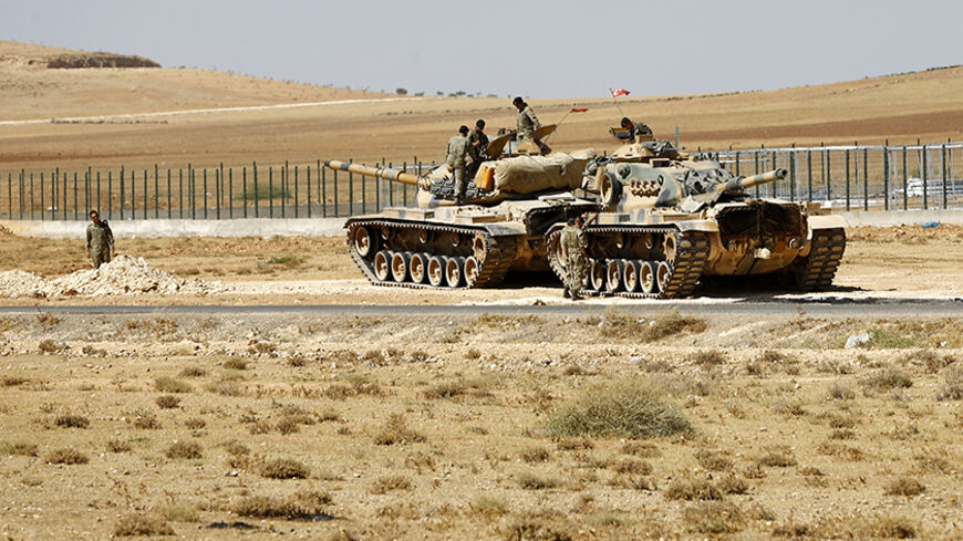 Turkish soldiers stand on top of tanks next to the Syrian-Trukish border fence near the town of Suruc in Sanliurfa province September 23, 2014. Some 138,000 Syrian Kurdish refugees have entered Turkey in an exodus that began last week, and two border crossing points remain open, the U.N. High Commissioner for Refugees said.    REUTERS/Murad Sezer (TURKEY  - Tags: POLITICS SOCIETY IMMIGRATION CONFLICT MILITARY)   - RTR47CIB