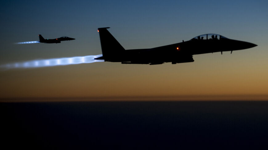 A pair of U.S. Air Force F-15E Strike Eagles fly over northern Iraq after conducting airstrikes in Syria, in this U.S. Air Force handout photo taken early in the morning of September 23, 2014. These aircraft were part of a large coalition strike package that was the first to strike ISIL targets in Syria. At least 14 Islamic State fighters were killed in air strikes by U.S.-led forces overnight in northeast Syria, a group monitoring the war said on September 25, 2014, and the Syrian air force bombed rebel ar