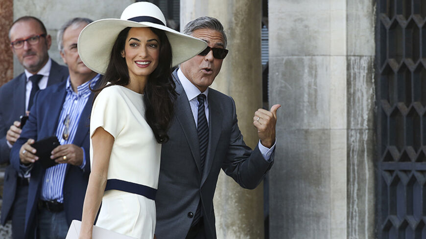 U.S. actor George Clooney and his wife Amal Alamuddin arrive at Venice city hall for a civil ceremony to formalize their wedding in Venice September 29, 2014. REUTERS/Alessandro Bianchi (ITALY - Tags: ENTERTAINMENT) - RTR485U1