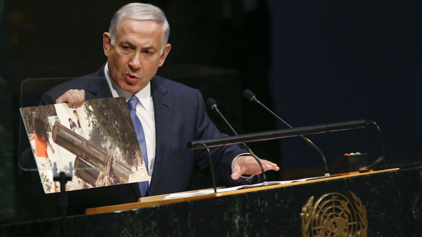 Israel's Prime Minister Benjamin Netanyahu talks about a photograph as he addresses the 69th United Nations General Assembly at the U.N. headquarters in New York September 29, 2014.  REUTERS/Shannon Stapleton   (UNITED STATES - Tags: POLITICS) - RTR487W3