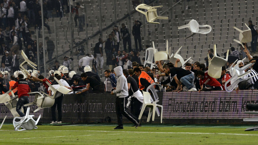 Besiktas fans throw plastic chairs onto the pitch during the Turkish Super League derby soccer match between Besiktas and Galatasaray at Ataturk Olympic Stadium in Istanbul late September 22, 2013. Hundreds of fans halted the Istanbul derby after storming the pitch at Istanbul's Olympic Stadium on Sunday, local media reported. Galatasaray were leading 2-1 in the third minute of added time when the match was halted, sending the players sprinting for the safety of the locker rooms. Picture taken September 22,
