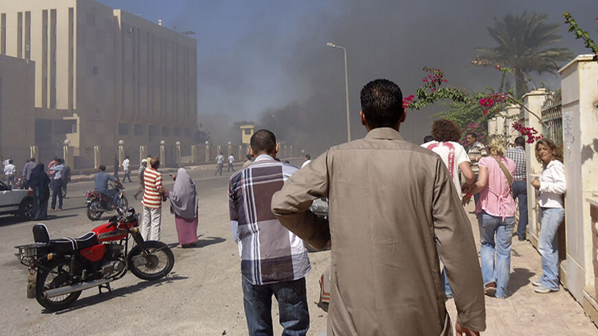 Residents and tourists watch as smoke raises near a state security building after a blast in South Sinai October 7, 2013. Medical sources said three were killed and 48 injured in the blast near the state security building in South Sinai. A witness said it was caused by a car bomb.  REUTERS/Stringer (EGYPT - Tags: POLITICS CIVIL UNREST) - RTX142T0