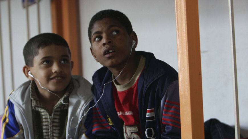 Orphan boys share earphones as they listen to music in their room in the Safe House orphanage in Baghdad's Sadr City February 11, 2009. As violence finally fades and U.S. troops prepare to withdraw, sociologists and health experts say the children's reactions to such trauma could threaten Iraq's fragile calm just as it needs stability to rebuild. Picture taken February 11, 2009. To match feature IRAQ-ORPHANS/    REUTERS/May Naji (IRAQ) - RTXC8UP