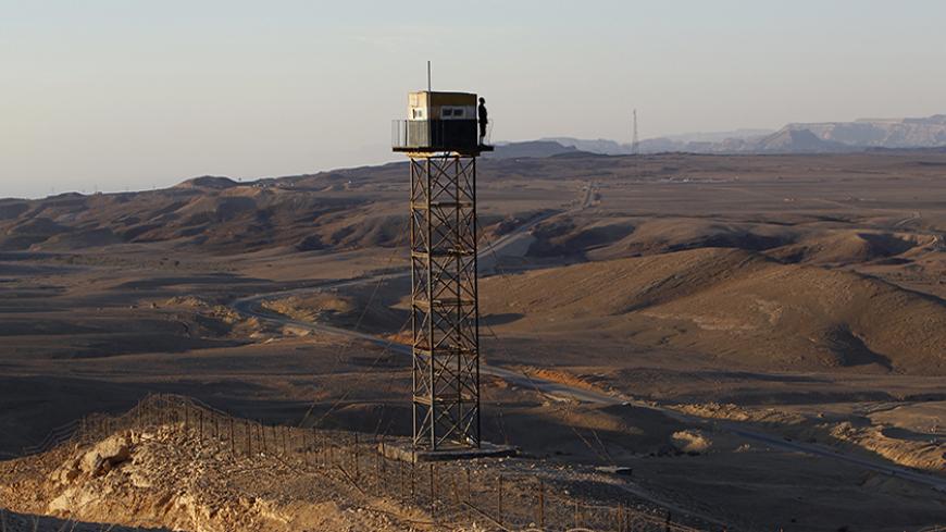 An Egyptian soldier stands guard on a watch tower on the border between Israel and Egypt, some 30 km (19 miles) north of Eilat, November 29, 2010. Last week Israel began work to construct a barrier to seal off part of the border with Egypt's Sinai desert from where many of the migrants enter the Jewish state. REUTERS/Ronen Zvulun (EGYPT - Tags: POLITICS MILITARY IMAGES OF THE DAY) - RTXV7JY