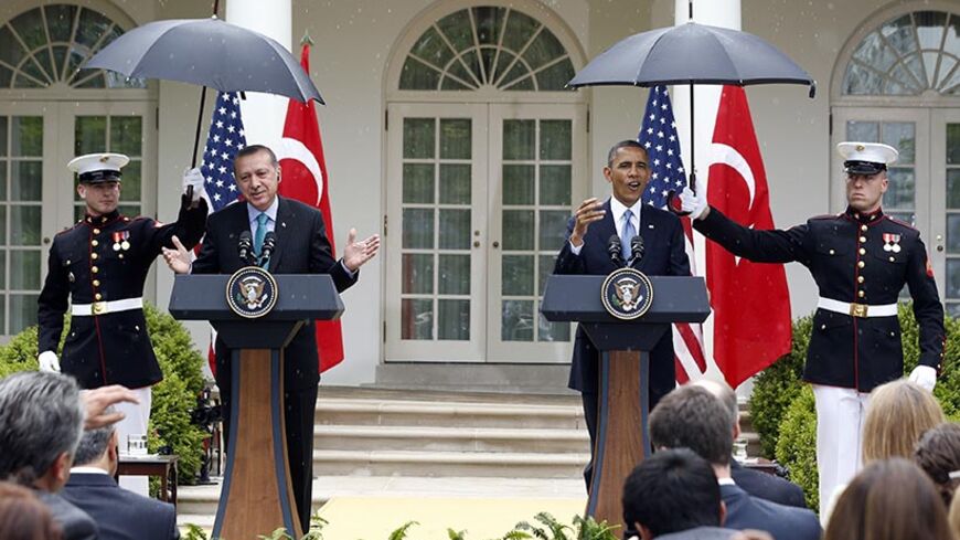  U.S. Marines move into position with umbrellas as rain falls during a joint news conference between U.S. President Barack Obama (C) and Turkish Prime Minister Recep Tayyip Erdogan (L) in the White House Rose Garden in Washington, May 16, 2013. REUTERS/Jason Reed (UNITED STATES  - Tags: POLITICS)   - RTXZPE2