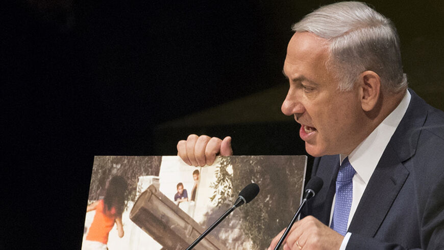 Israel's Prime Minister Benjamin Netanyahu talks about a photograph as he addresses the 69th United Nations General Assembly at the U.N. headquarters in New York September 29, 2014. REUTERS/Brendan McDermid (UNITED STATES - Tags: POLITICS) - RTR4886J