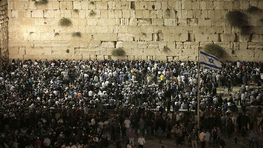 Thousands of Jews perform the Selichot prayer at the Western Wall, Judaism's holiest site, in the old city of Jerusalem late on September 23, 2014, in the lead up to Rosh Hashana, the Jewish New Year. Clashes broke out at Al-Aqsa mosque compound, Islam's third holiest shrine, as Palestinians protested against members of Jewish faith visiting the flashpoint holy site, which is also sacred to the Jews and known to them as Temple Mount, on the eve of Jewish New Year, police said. AFP PHOTO/ AHMAD GHARABLI     