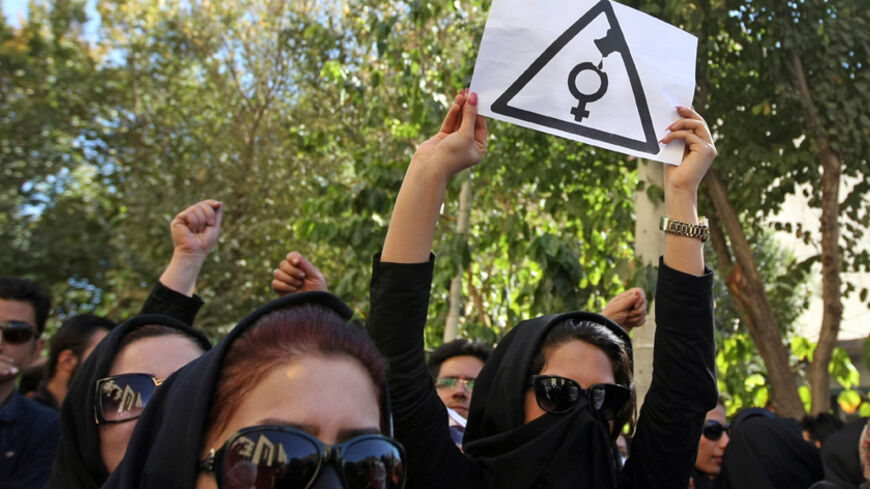 Iranian women, hiding their faces not to be identified, shout slogans during a protest in front of the judiciary building on October 22, 2014 in Isfahan, 450 kilometres south of Tehran, in solidarity with women injured in a series of acid attacks. Around 1,000 people took part in the protest calling for better security with banners and placards demanding action after four women have been maimed by assailants on motorcycles who threw acid on them. The acid attacks have prompted speculation on social networks