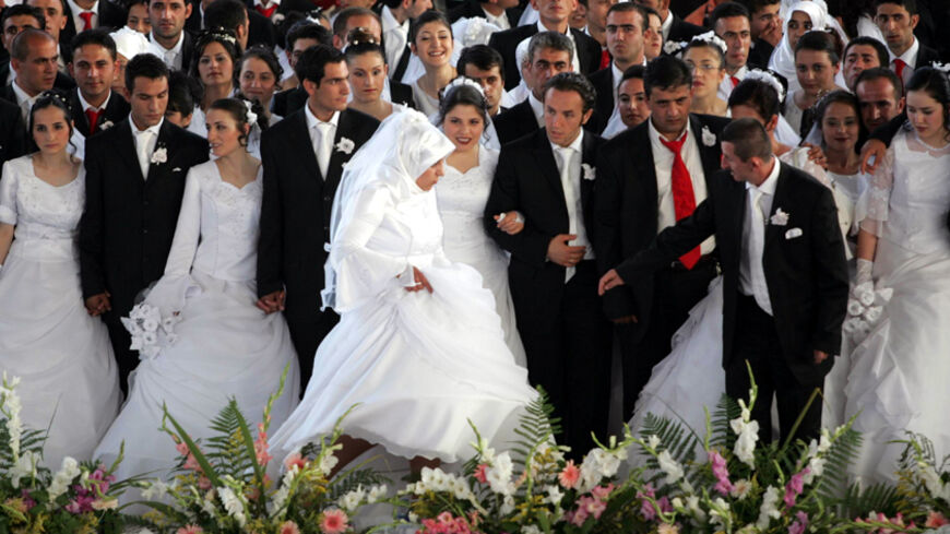 Brides and bridegrooms gather on a stage as they wait for their wedding ceremony in Ankara August 6, 2006. The 206 couples got married in an annual ceremony organised by Ankara municipality. REUTERS/Umit Bektas  (TURKEY) - RTR1G5NN