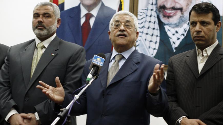 Palestinian President Mahmoud Abbas (C) stands between Prime Minister Ismail Haniyeh (L) and senior Fatah leader Mohammed Dahlan during the letter of appointment ceremony in Gaza February 15, 2007. Abbas formally asked Haniyeh of Hamas on Thursday to form a new unity government and urged him to abide by peace accords signed with Israel. REUTERS/Suhaib Salem (GAZA) - RTR1MG8Z