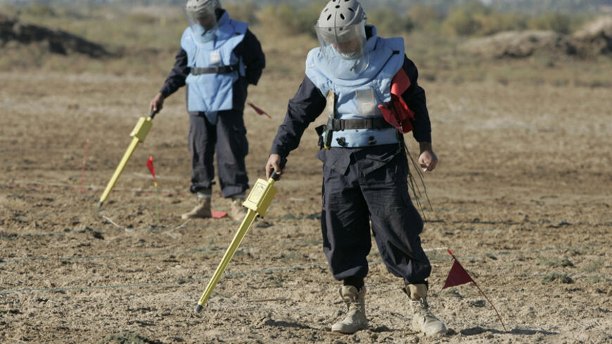 An NGO de-miners search for unexploded ordnance in a field in Radhwaniya district western Baghdad December 7, 2008.   REUTERS/Saad Shalash (IRAQ) - RTR22CL7