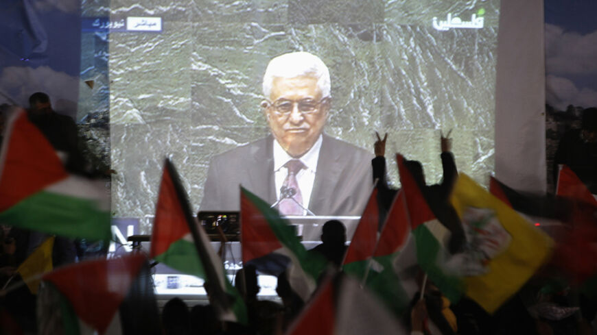 Palestinians take part in a rally while the speech of Palestinian President Mahmoud Abbas is being projected in the West Bank city of Ramallah November 29, 2012. The 193-nation U.N. General Assembly overwhelmingly approved a resolution on Thursday to upgrade the Palestinian Authority's observer status at the United Nations from "entity" to "non-member state," implicitly recognizing a Palestinian state.   REUTERS/Mohamad Torokman (WEST BANK - Tags: POLITICS) - RTR3B1GJ